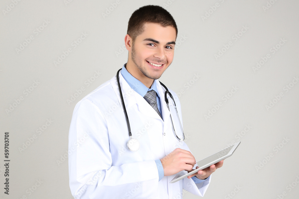 Male Doctor standing with folder, on gray background Male Doctor standing with folder, on gray background