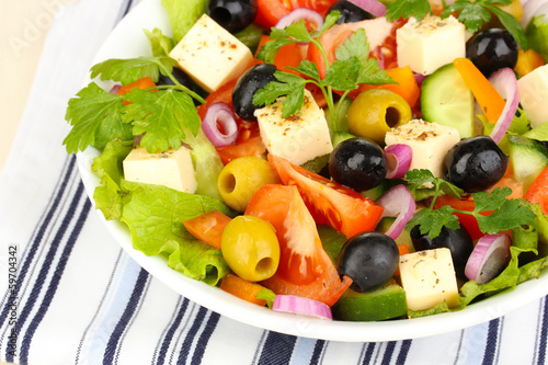 Greek salad in plate on napkin close up