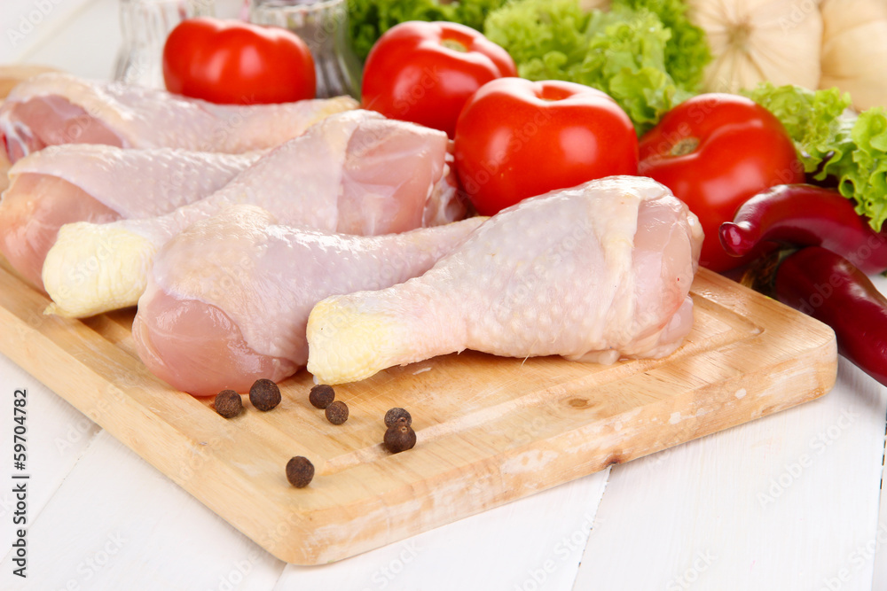 Raw chicken legs on wooden board close up Raw chicken legs on wooden board close up