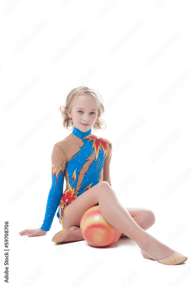 Stately little gymnast sitting in studio with ball Stately little gymnast sitting in studio with ball