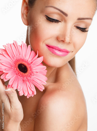 Portrait of beautiful woman with bright makeup and pink daisies