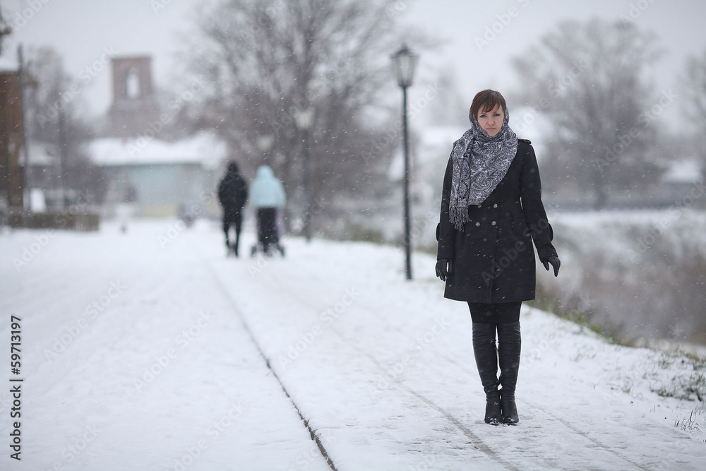 woman walking in a small town snow woman walking in a small town snow