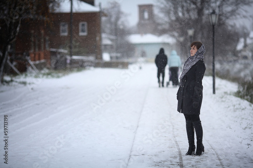 woman walking in a small town snow