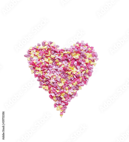 Pink heart made of candys on white background