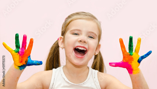 Cute happy little girl with hands in paint