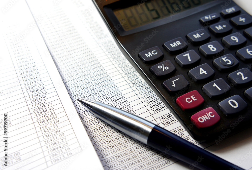 Office table with calculator, pen and accounting document
