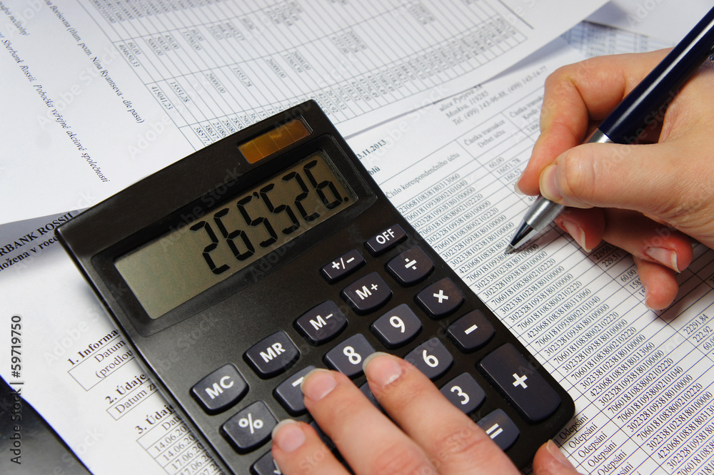 Office table with calculator, pen and accounting document Office table with calculator, pen and accounting document