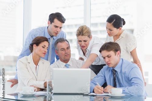 Business colleagues with laptop at desk