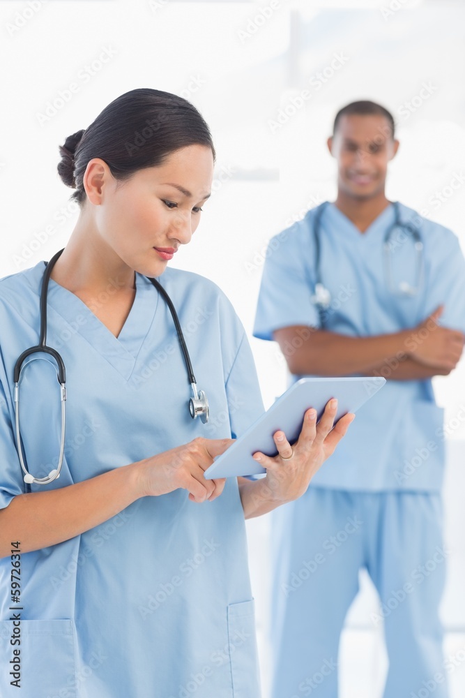 Beautiful female surgeon holding digital tablet Beautiful female surgeon holding digital tablet