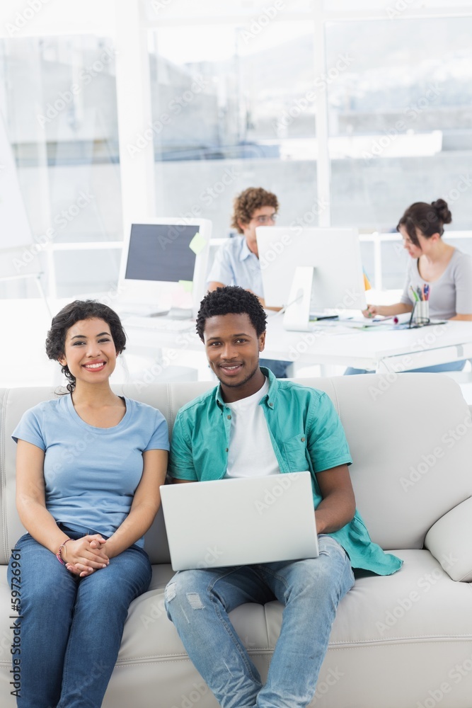 Couple using laptop with colleagues at creative office Couple using laptop with colleagues at creative office