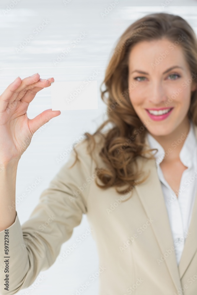 Smiling businesswoman holding blank card Smiling businesswoman holding blank card