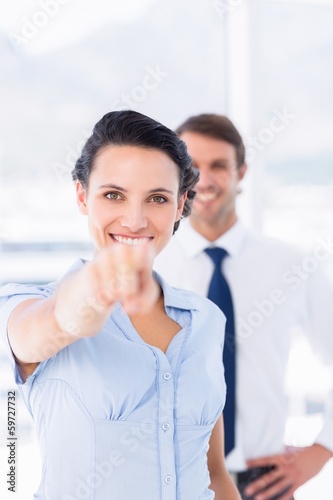 Free Download Woman pointing at camera with colleague in background - GFXLoad