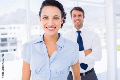 Smiling businesswoman with male colleague in background Free Download Smiling businesswoman with male colleague in background - GFXLoad