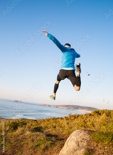 Man giving a big jump and practicing trail running