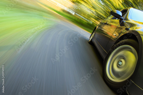 Front side view of luxury sedan in turn with blurred motion.