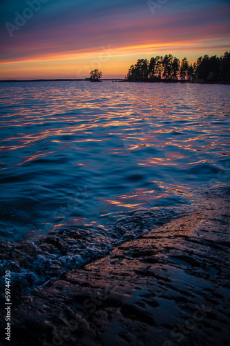 Golden blue Sunset over Scandinavian rocky lake forest