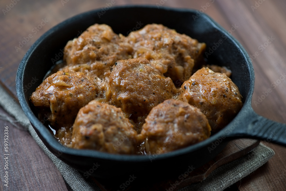 Meatballs with gravy in cast-iron pan, close-up, horizontal shot Meatballs with gravy in cast-iron pan, close-up, horizontal shot