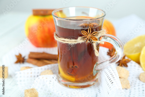 Hot beverage in glass cup with fruits and spices,