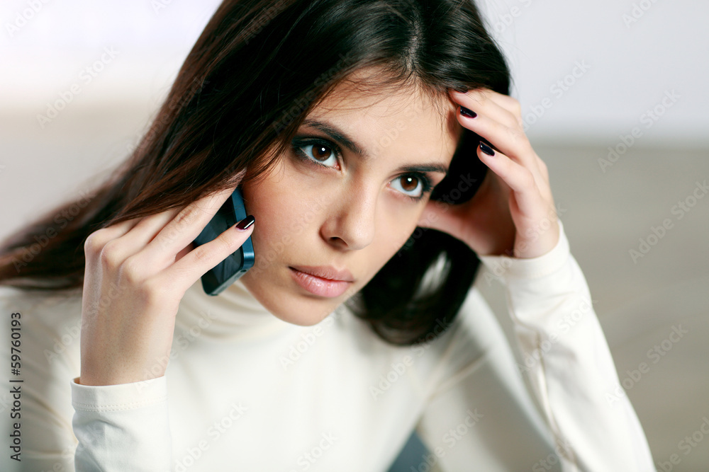 Young pensive woman talking on the phone Young pensive woman talking on the phone
