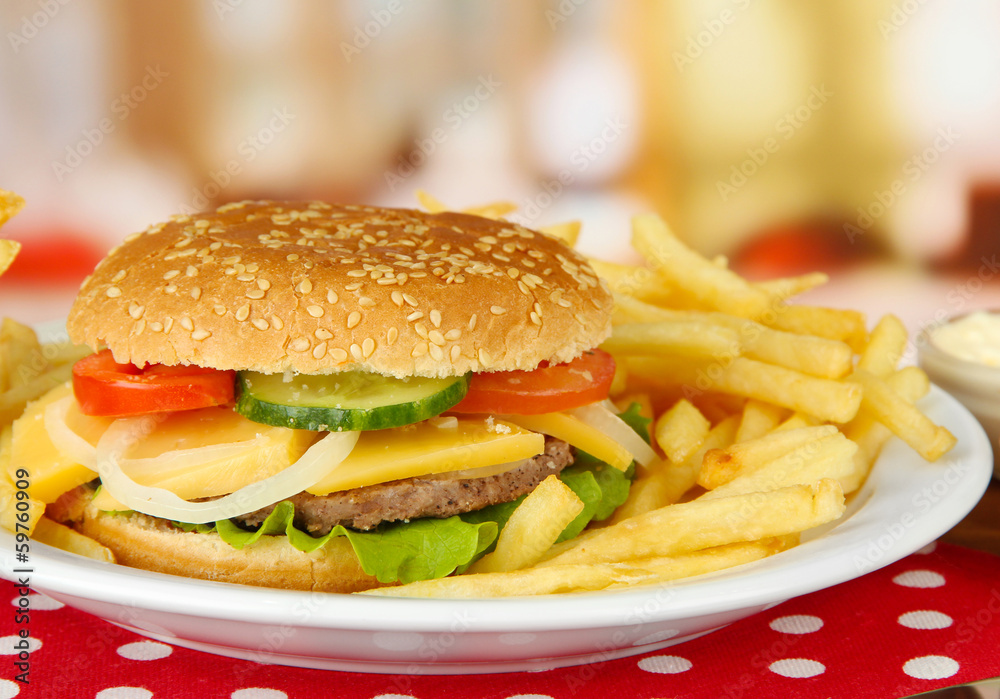 Tasty cheeseburger with fried potatoes, on bright background Tasty cheeseburger with fried potatoes, on bright background