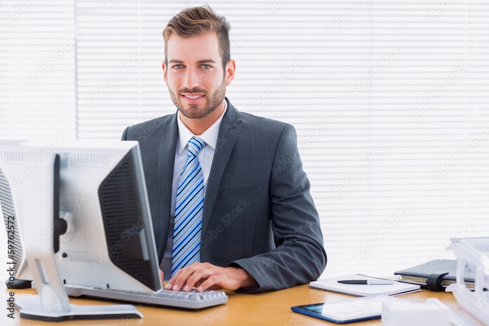 Young businessman using computer at office desk Young businessman using computer at office desk