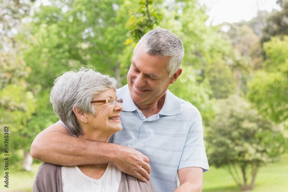 Senior man embracing woman from behind at park