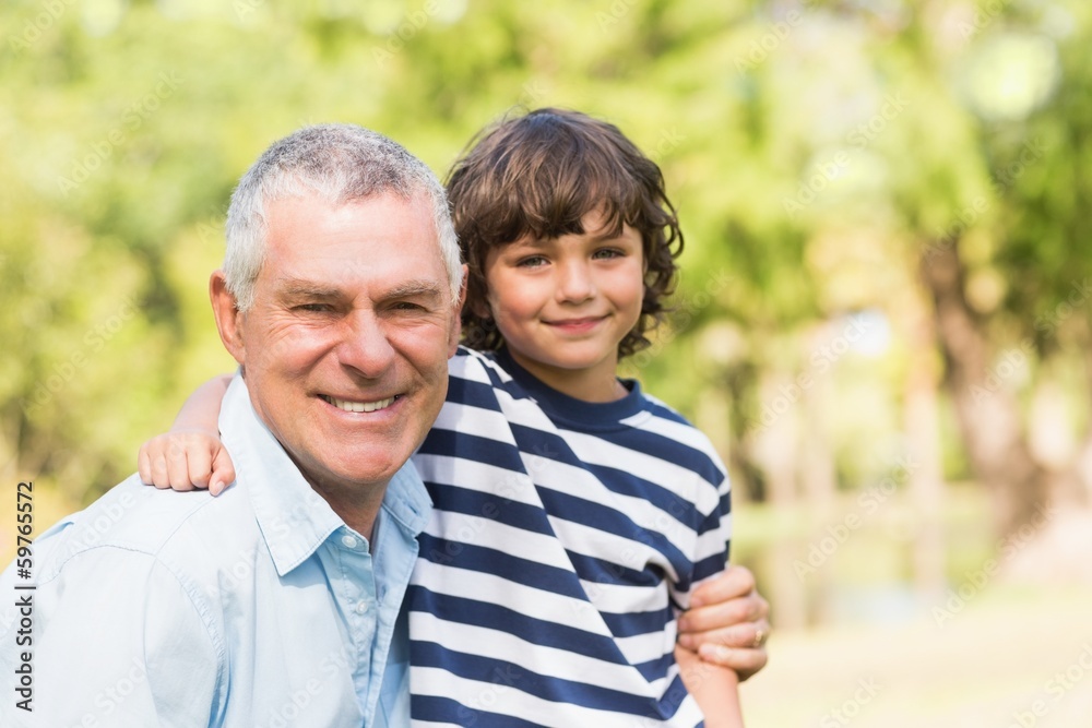 Grandfather and son smiling in park