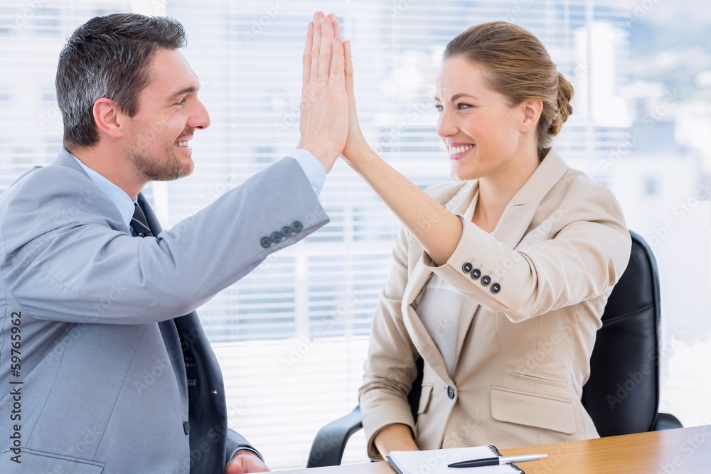 Colleagues giving high five in business meeting Colleagues giving high five in business meeting