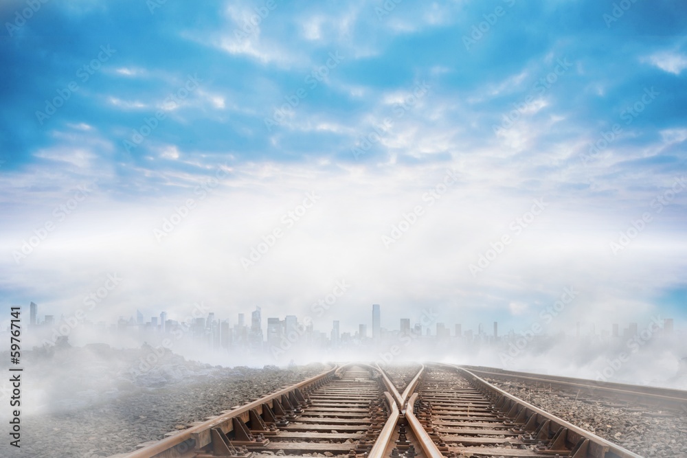 Fototapeta premium Train tracks leading to city on the horizon