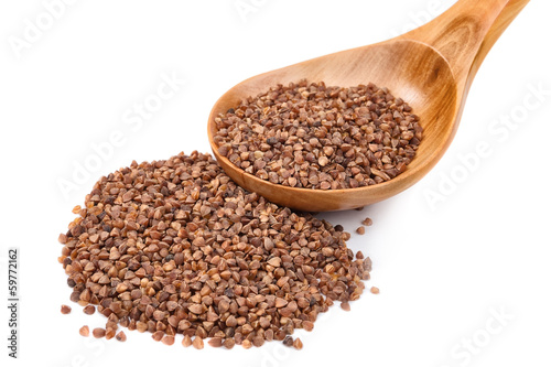 Dry raw buckwheat on wooden spoon. on white background.
