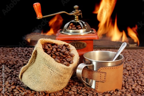 Stainless Steel Coffee Mug and old Grinder with beans photo