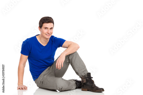 Male student sitting on the floor.
