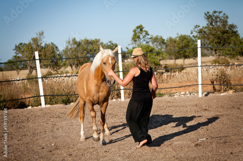junge weibliche reiterin trainiert ihr pferd im freien im sommer