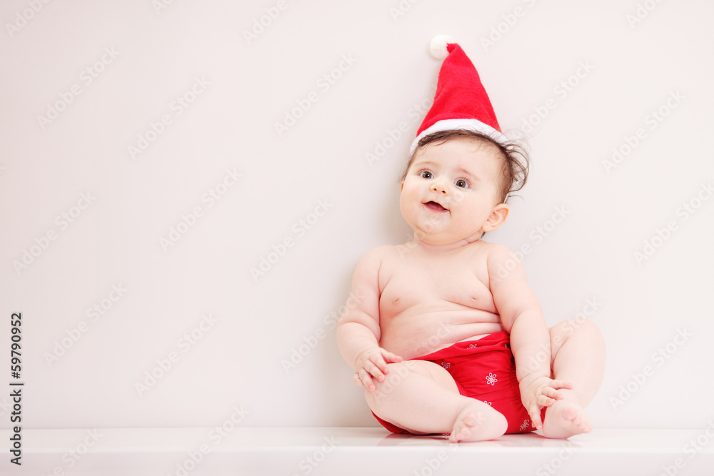 Little cute baby girl with a santa hat on a table Little cute baby girl with a santa hat on a table