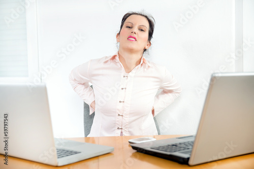 Young businesswoman having back pain 