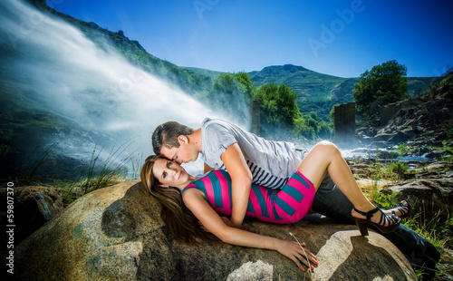 Casal apaixonado deitado sobre as rochas photo