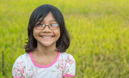 A young Malay Asian girl in front of a rice field