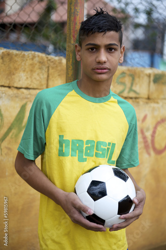 Young Brazilian Football Player Holding Soccer Ball © lazyllama