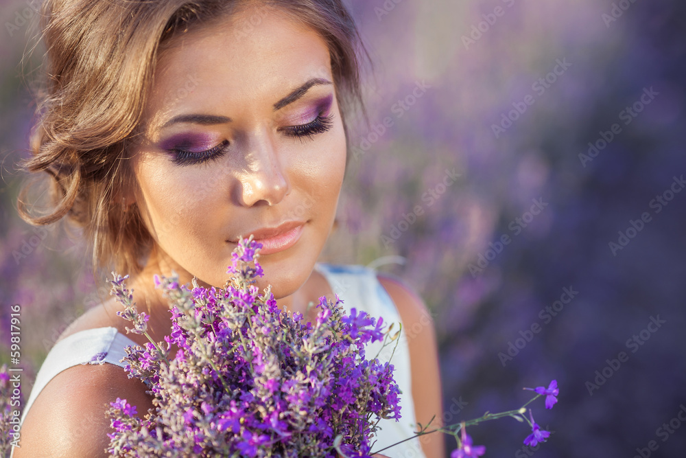 Beautiful young woman relaxing in a lavender field at sunset Beautiful young woman relaxing in a lavender field at sunset