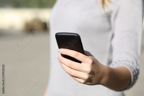 Woman hand holding and browsing a smart phone outdoor