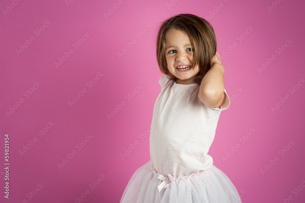 Young dancer girl portrait against pink background.
