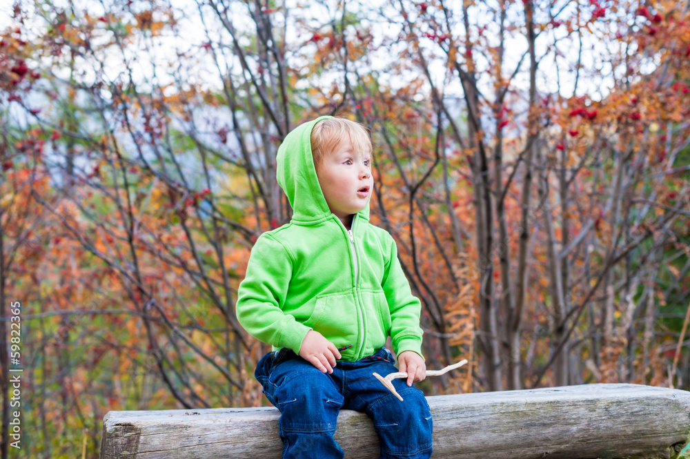 Cute toddler boy resting in a forest Cute toddler boy resting in a forest