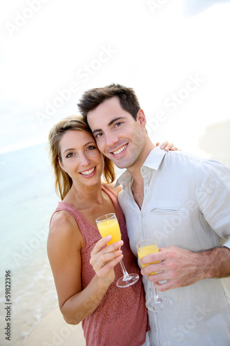 Couple enjoying cocktail on caribbean beach