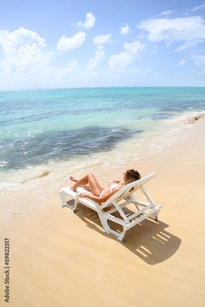 Woman relaxing in long chair by the beach Woman relaxing in long chair by the beach