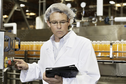 Man looking at tablet PC while working in bottling factory
