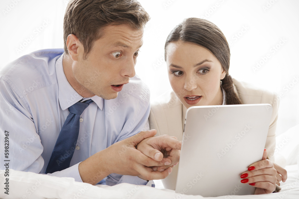 Shocked business couple using digital tablet in hotel Shocked business couple using digital tablet in hotel