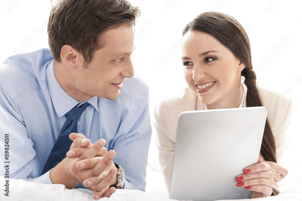 Happy business couple with digital tablet looking at each other in hotel Happy business couple with digital tablet looking at each other in hotel