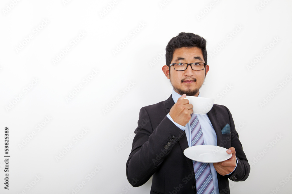 Portrait of confident young businessman holding coffee cup and plate over white background Portrait of confident young businessman holding coffee cup and plate over white background