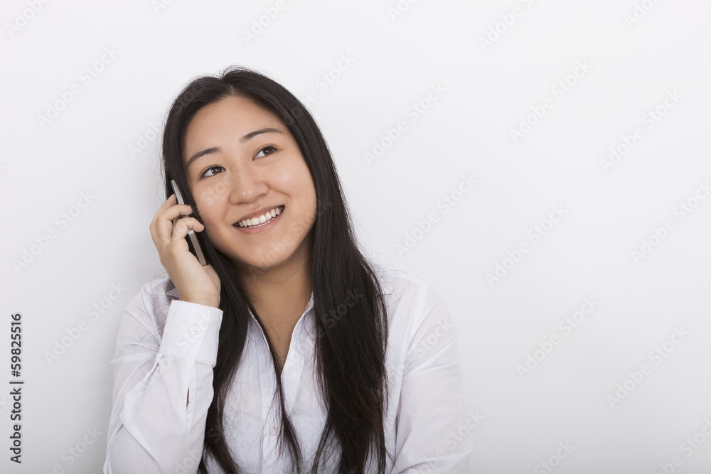 Happy woman answering cell phone against white background Happy woman answering cell phone against white background
