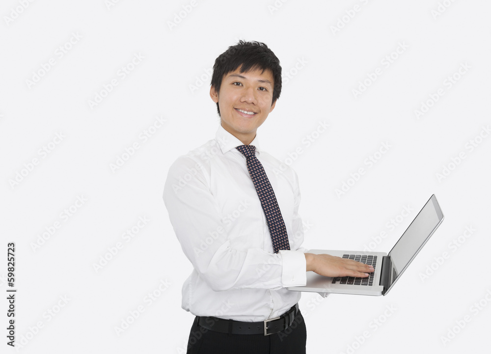 Portrait of happy mid adult businessman using laptop over white background Portrait of happy mid adult businessman using laptop over white background